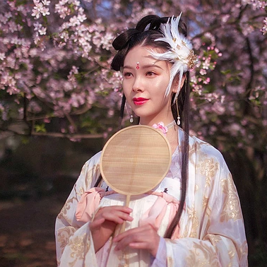 粉色桃花拂面帶團扇女生頭像，唯美古風真人頭