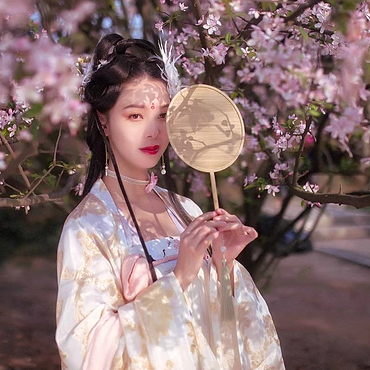 粉色桃花拂面帶團扇女生頭像，唯美古風真人頭